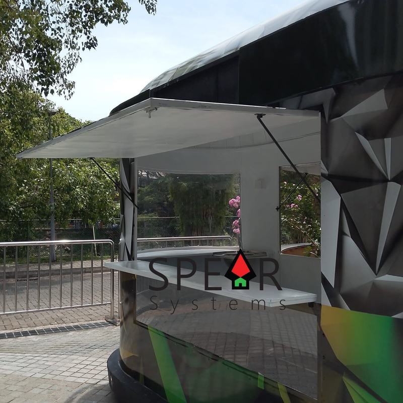 A kiosk with its hatch folded up into an awning, showing the stainless serving counter and prep area inside