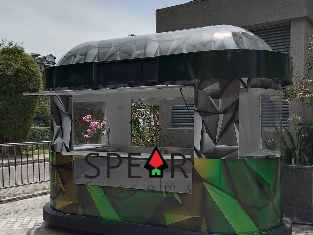 The Nai Mirisa Hoppers kiosk: a curved kiosk with a domed roof, green faceted wrap, open serving hatch and steel counter
